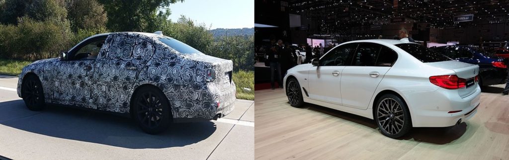 Dois carros da BMW lado a lado, um com camuflagem automotiva e o outro em exibição em um salão de automóvel.